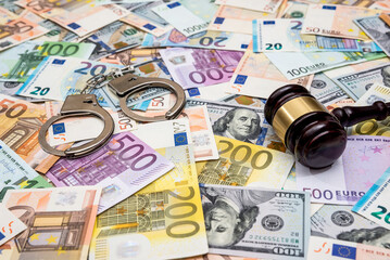 Dolar and euro bills with handcuff, judge gavel as legal finance concept