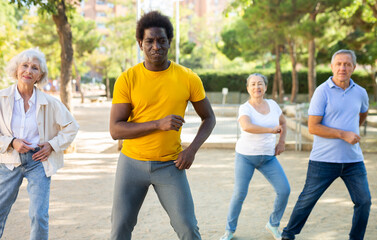 Happy multiracial adult people with different ages having fun doing aerobics outdoor