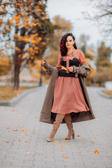 A woman walks outdoors in autumn, enjoys the autumn weather.