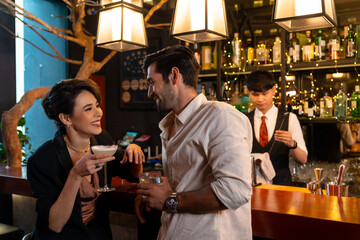 Caucasian man and woman flirting each other while hangout nightlife party at restaurant bar. Attractive female have romantic dating with boyfriend celebrating holiday event together at nightclub