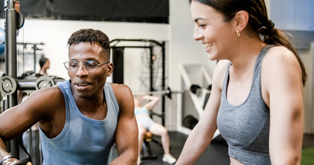 Fototapeta na wymiar Fit trainer explaining exercise to woman in gym