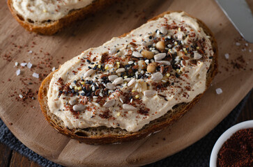 Hummus Toast with Rustic Bread, Vegetarian Snack or Breakfast on Wooden Background