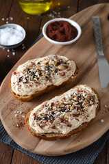 Hummus Toast with Rustic Bread, Vegetarian Snack or Breakfast on Wooden Background