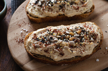 Hummus Toast with Rustic Bread, Vegetarian Snack or Breakfast on Wooden Background