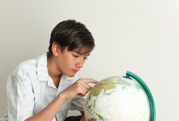 Portrait of a school boy with the globe.  Closeup Young element school kid looking the map learning...