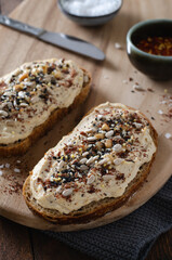 Hummus Toast with Rustic Bread, Vegetarian Snack or Breakfast on Wooden Background