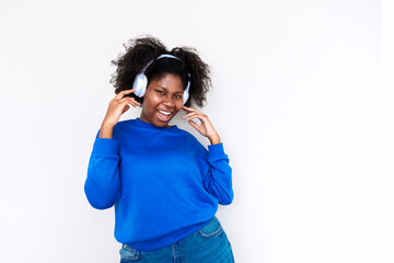 Afro woman enjoying music with headphones against white background