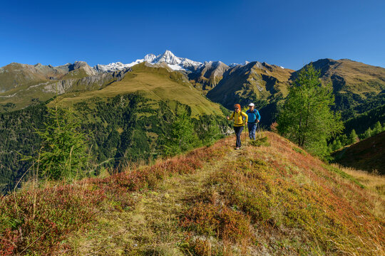 Man and woman hiking on mountain in Hohe Tauern National Park, Austria