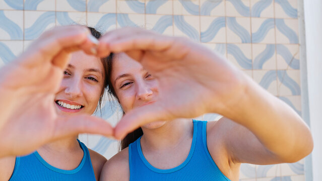 Happy girls gesturing heart shape