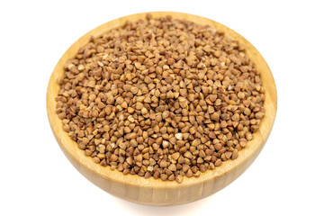 Naklejka premium Buckwheat isolated on white background. Buckwheat grains in wooden bowl. Close up