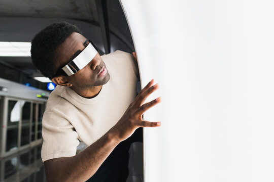 Futuristic man with cyber glasses examining light pane