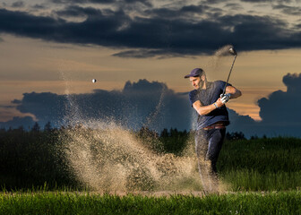 Man hitting golf ball at dusk