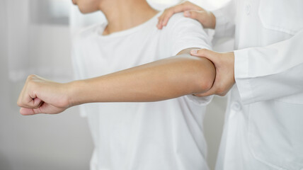 Female physiotherapists provide assistance to male patients with elbow injuries and examine patients in rehabilitation centers. Physiotherapy concepts