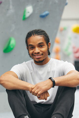 Portrait Of Smiling Young Man Excited To Try Climbing Wall At Indoor Centre