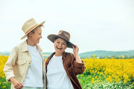 Happy lesbians wearing cowboy hat standing at field