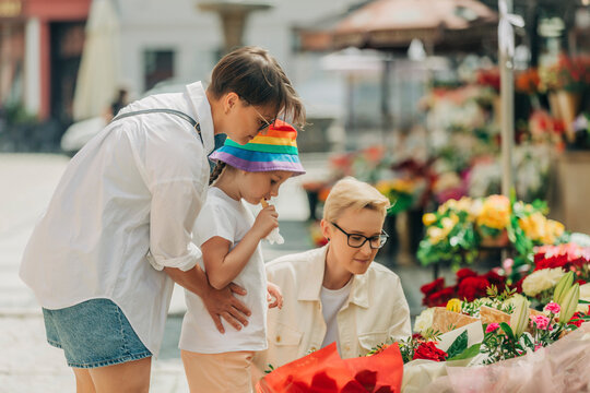 Lesbian couple with daughter buying flowers from shop