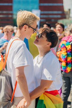 Loving lesbians standing and embracing each other at gay pride event