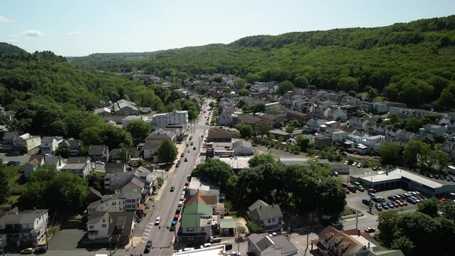 High aerial over Tamaqua Pennsylvania small coal mining town with green rolling hills