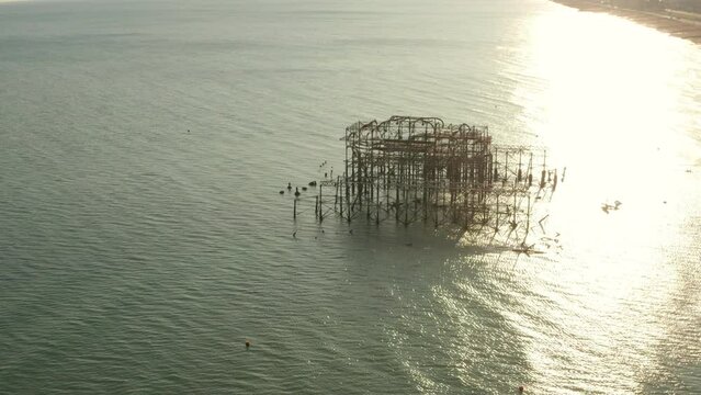 Low circling aerial shot of Old Brighton Pier