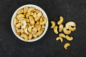 top view of bowl of Tasty cashew nuts on grunge background
