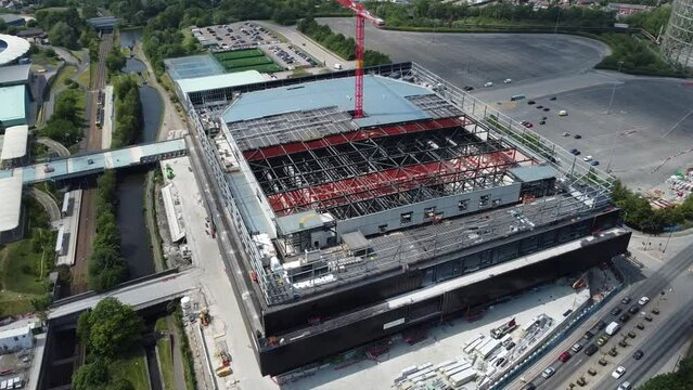 Slow sideways 4K cinematic drone clip over the construction site of the Co-op Live arena and traffic below near the Etihad campus in Manchester, UK