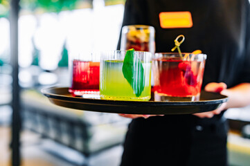 glasses alcohol cocktail set on a waiter tray in cafe