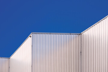 Aluminum Corrugated Industrial Building against blue clear sky Background in low angle and Perspective side view