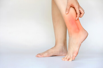 Woman's ankle with inflammation and pain showing red area. Health care concept.