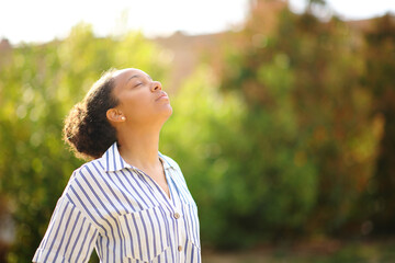 Black woman breathing fresh air in a park