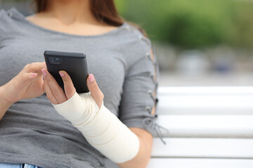 Convalescent woman with bandaged arm using phone