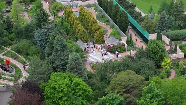 Wedding is happening in Botanic Gardens, Denver. Aerial drone view of people on ceremony.