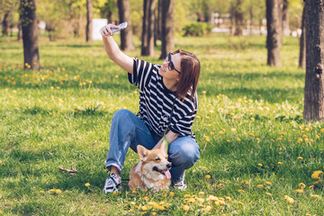 Friendship Concept.Excited caucasian woman taking selfie with her dog