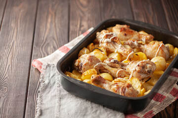Roasted chicken legs with potatoes in  roasting pan. Comfort home food