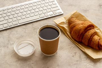 Coffee break in the office. Paper cup of coffee with keyboard, top view