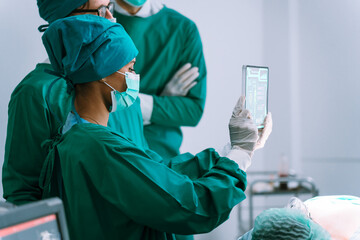 Group of expert medical team and their assistants work together in the operating room at the...