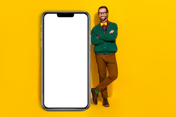Full body portrait of cheerful handsome guy crossed arms big empty space telephone isolated on yellow color background