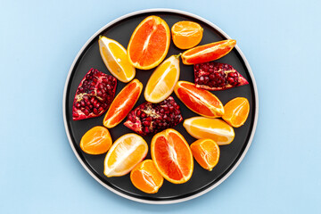 Many mixed fruits on white plate, top view