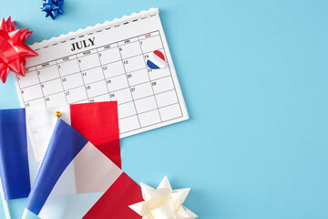 Fototapeta na wymiar July 14th Bastille Day celebration concept. Top view flat lay of french flags, calendar, patriotic bows on light blue background with blank space for promo or text