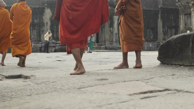 Buddhist Monks walking through Ancient Temple of Angkor Wat - Siem Reap, Cambodia