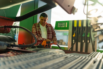 a truck driver fills his tank with fuel before continuing on his route, after a break at a gas...