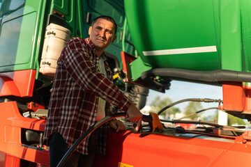 a truck driver fills his tank with fuel before continuing on his route, after a break at a gas...