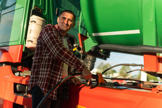 a truck driver fills his tank with fuel before continuing on his route, after a break at a gas station