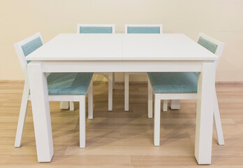 White table with four legs and four chairs with turquoise upholstery, furniture designed for office and home