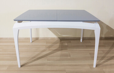 Gray table with white curved legs in a room interior, furniture design example