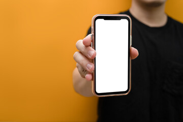 Closeup view man showing smartphone over green background. White empty screen for your webpage or advertise text