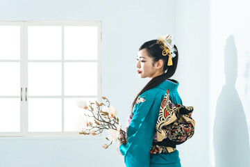 花を持つ振袖を着た女性のポートレート