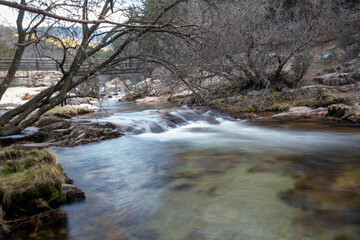 Impresionante paisaje de monta&ntilde;as rocosas en La Pedriza, con el r&iacute;o Manzanares serpenteando entre las formaciones de piedra. El agua cristalina fluye suavemente, creando peque&ntilde;as cascadas.