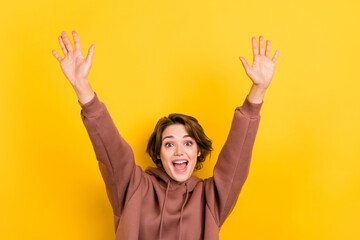 Photo of astonished nice lady raise arms palms open mouth isolated on yellow color background