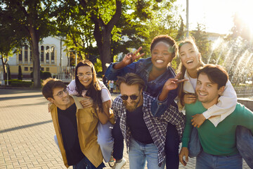 Young people having fun together. Group of six positive joyful diverse mixed race friends meet on...