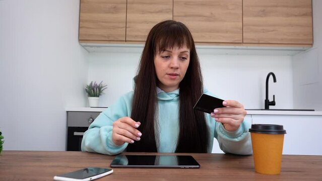 Online shopping. A woman pays with a credit card using a digital tablet.